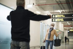 casal de idosos se reencontrando em desembarque dentro de aeroporto