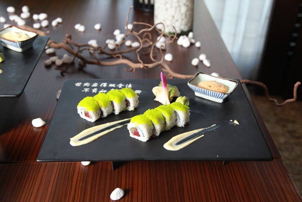 Porção de sushi decorada sobre mesa de madeira.