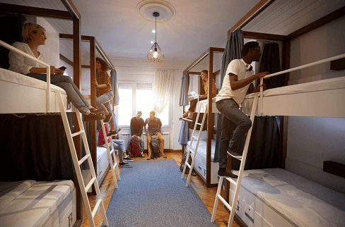 amigos em suas beliches sorrindo em um quarto compartilhado de um hostel